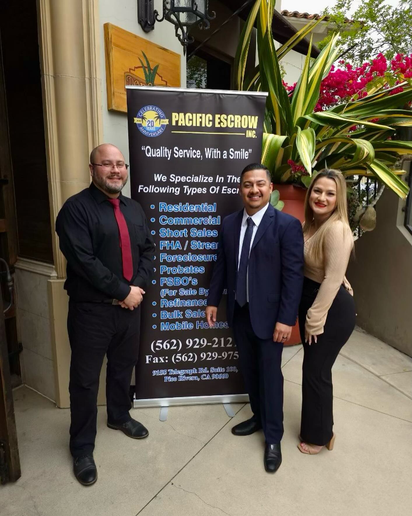 Pacific Escrow team members beside the 20-year anniversary banner